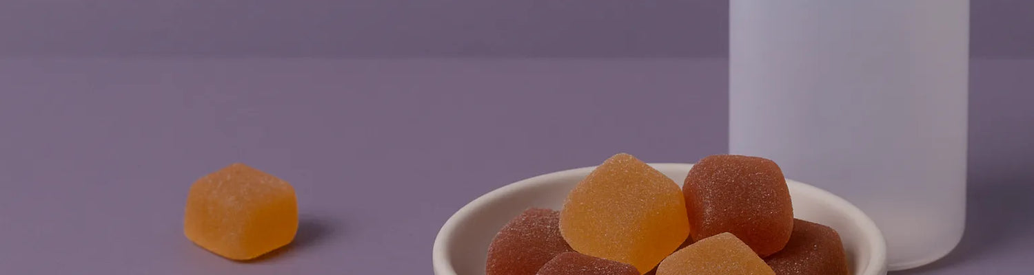 CBD és CBN melatonin gumicukorkák egy tálban, üveggel lila háttéren